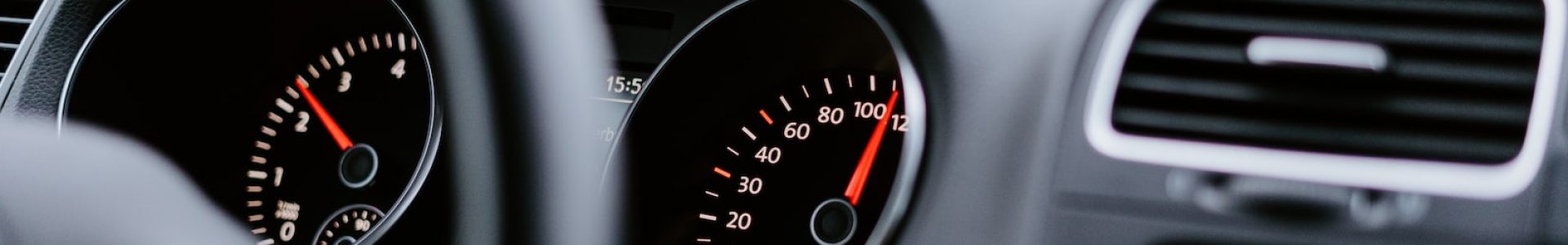 black vehicle dashboard with speedometer on 100