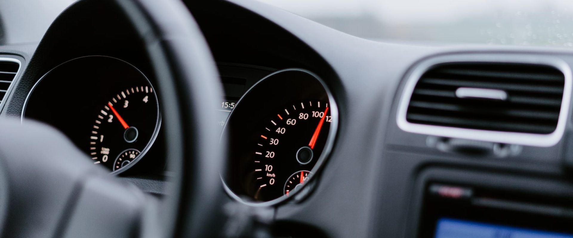 black vehicle dashboard with speedometer on 100