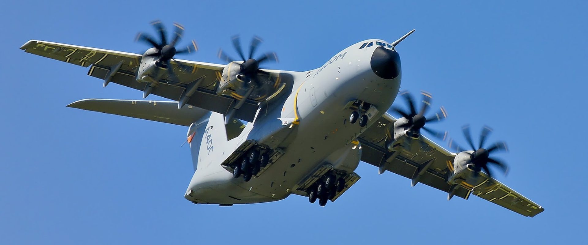 grey military cargo plane on flight under clear blue sky